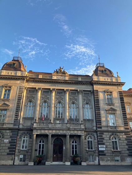 A historic building with ornate architecture, including columns and a dome. 2