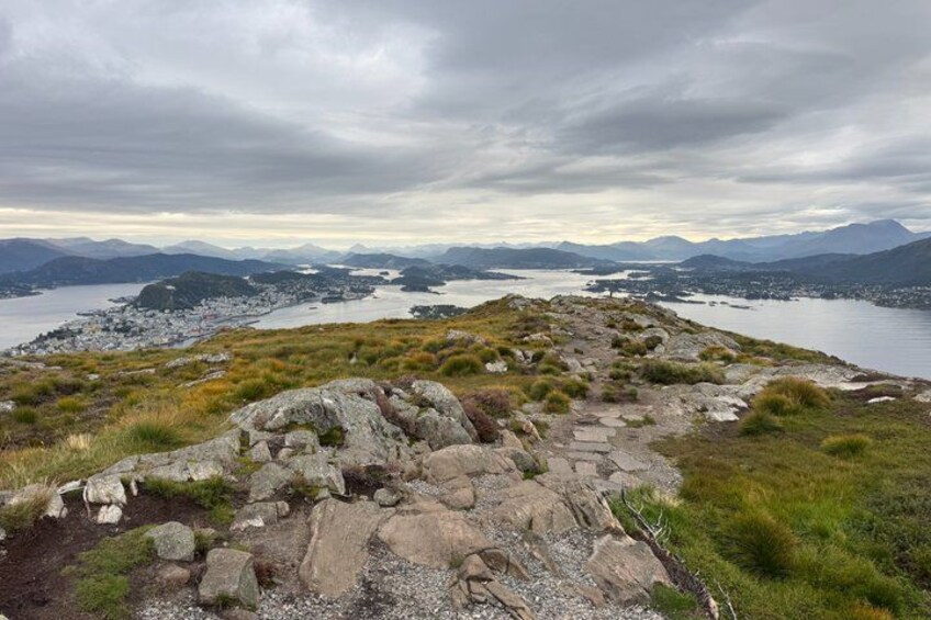 A rocky landscape with a lake and distant mountains under a cloudy sky. 2