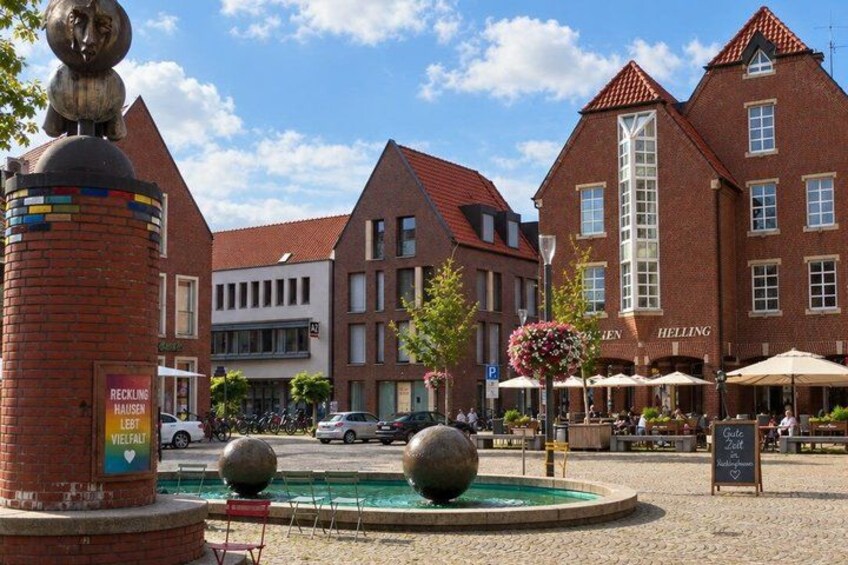 A public square with a fountain, a statue, and historic buildings. 4