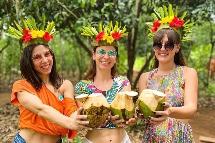 Three people holding coconuts with decorative headdresses. 1