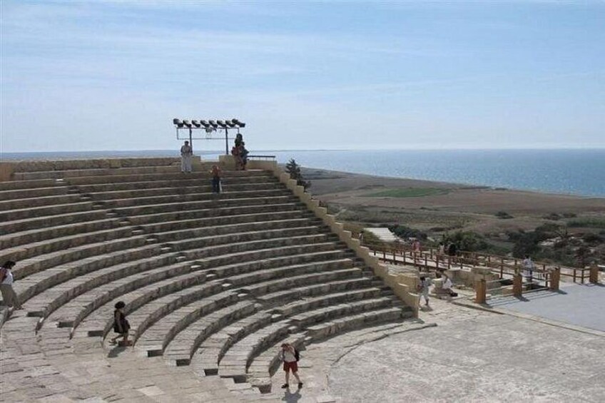 An ancient amphitheater with stone steps and a clear view of the sea. 3