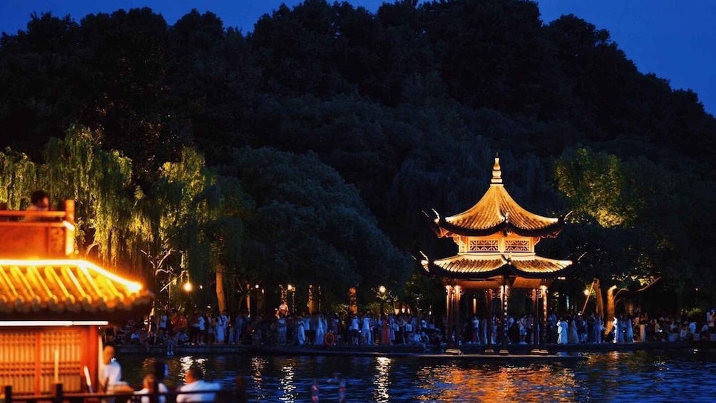 A traditional Chinese pavilion by a lake at night. 5