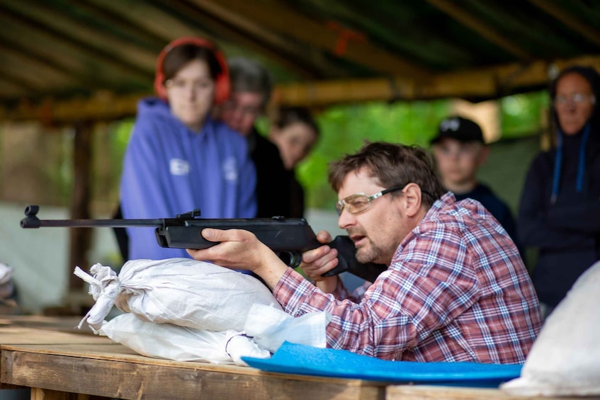 A person aiming a rifle at a target. 1