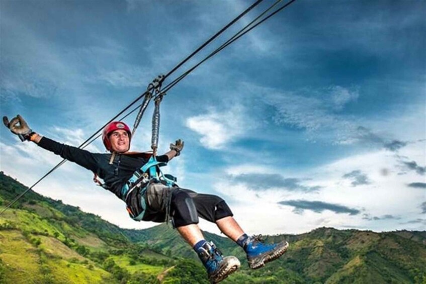 Una persona che fa zipline sopra un paesaggio montuoso. 1