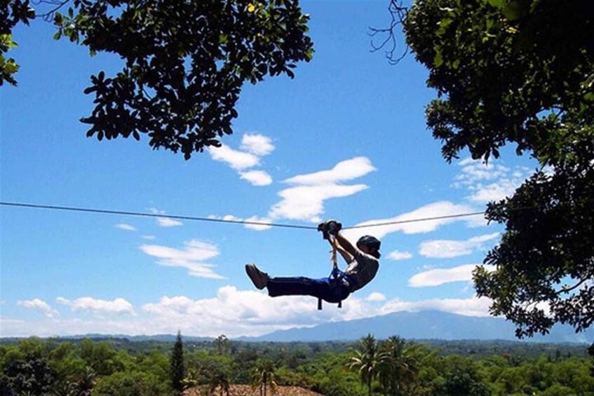 Una persona fa bungee jumping con una vista chiara del paesaggio e montagne sullo sfondo. 3