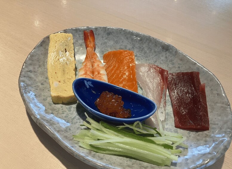 A plate with various types of sashimi, including salmon, tuna, and shrimp, along with pickled ginger and wasabi. 3