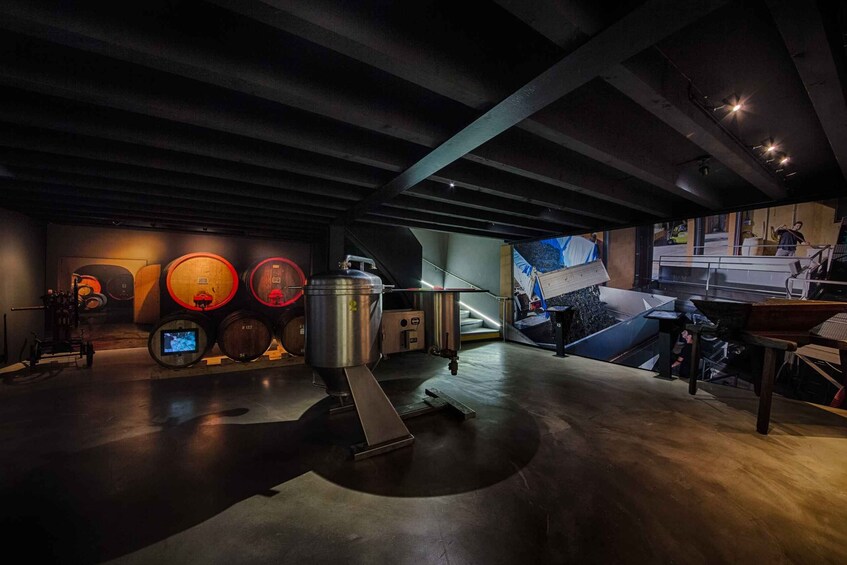 A modern industrial space with exposed beams, large metal containers, and a mezzanine level. 2