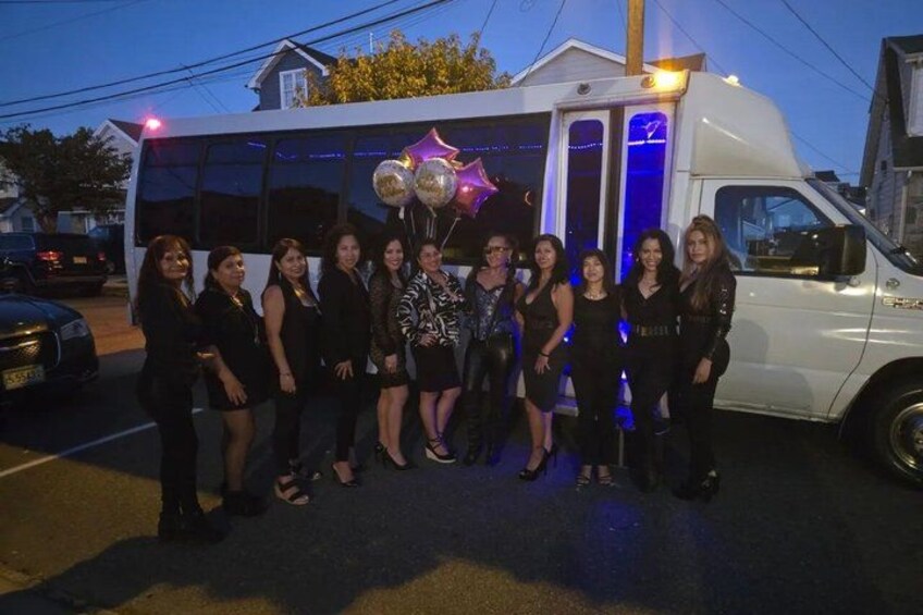 A group of people standing in front of a white van with a star decoration and balloons. 4