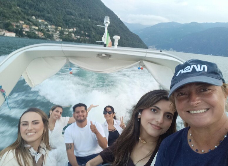A group of people on a boat with a mountainous landscape in the background. 3
