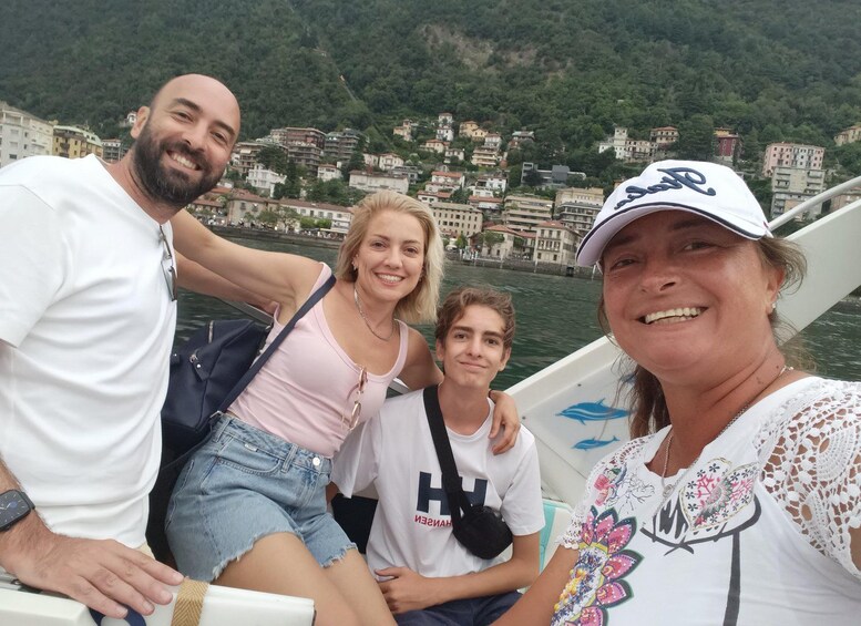 A group of people on a boat with a mountainous town in the background. 5