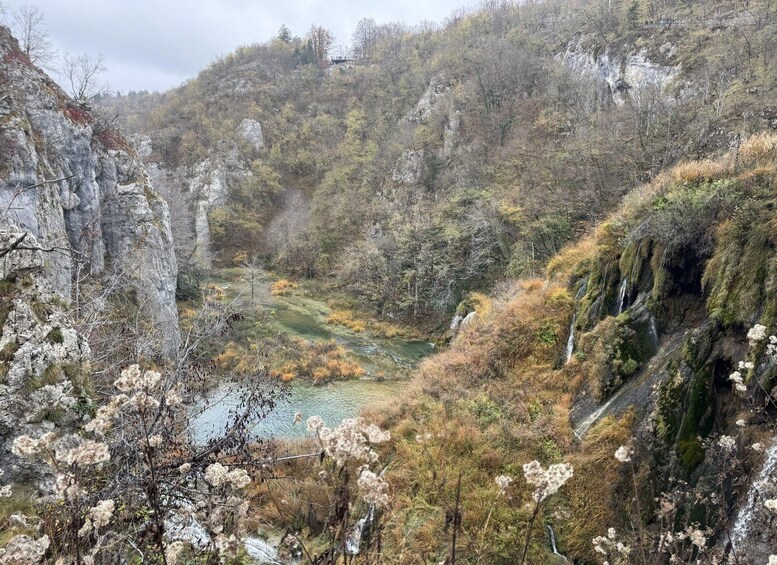 A valley with a river, rocky cliffs, and autumn foliage. 1