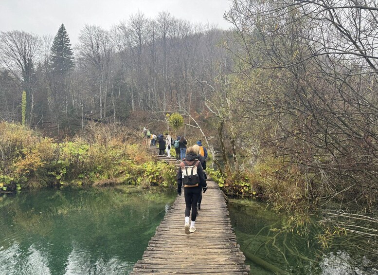 A wooden bridge over a river with people walking on it. 5