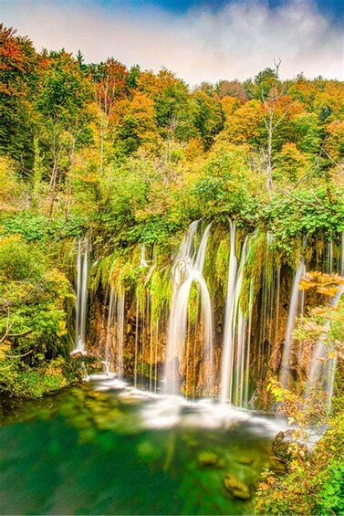 A waterfall surrounded by autumn foliage. 4