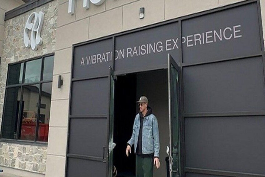A person exiting a building with a sign that reads 'A VIBRATION RAISING EXPERIENCE.' 5