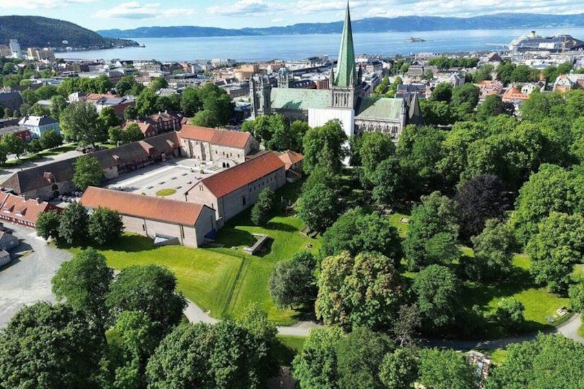 A town with a prominent church, a castle-like building, and a body of water in the background. 1