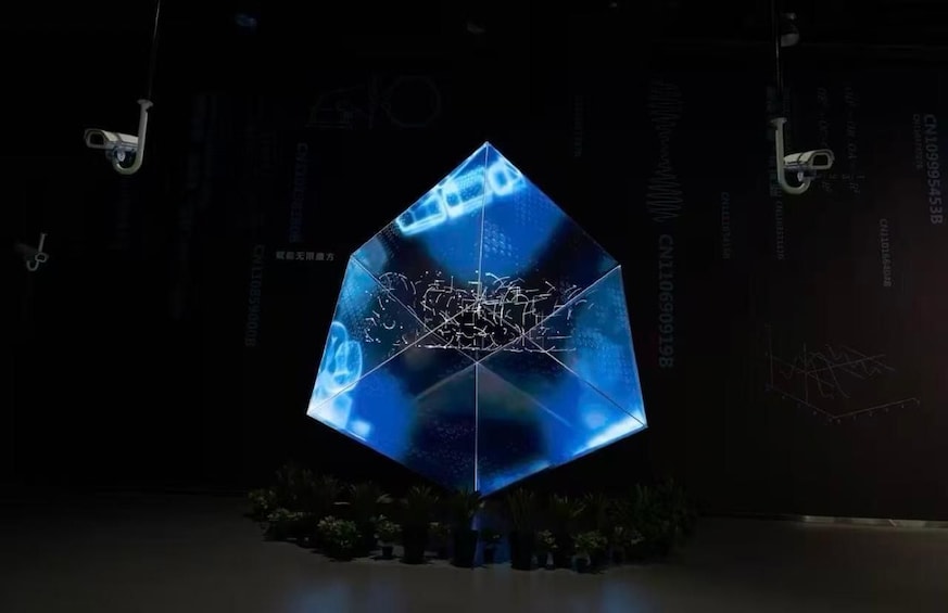A large, illuminated geometric sculpture with digital patterns. 3