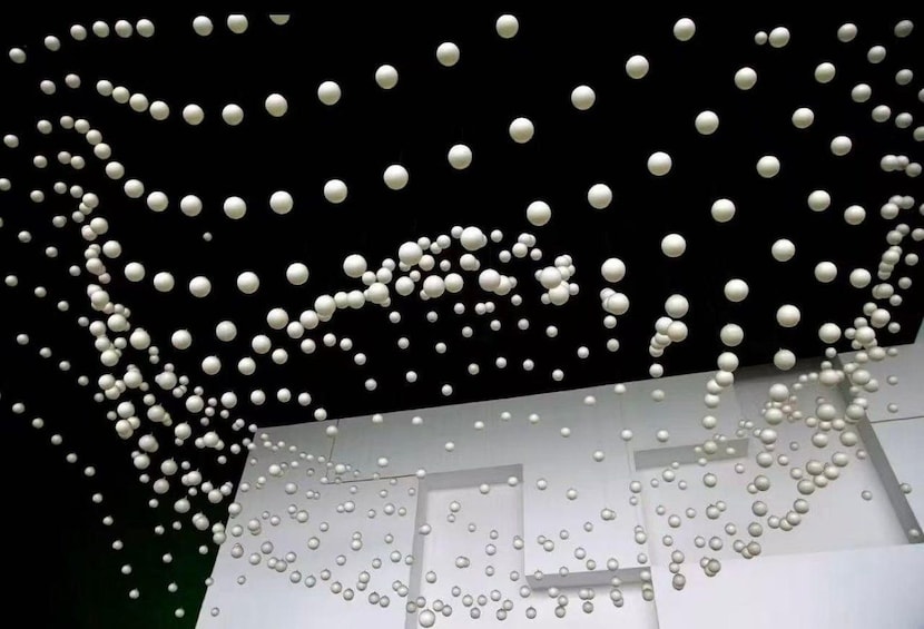 A ceiling with numerous white spherical objects suspended in a pattern. 2