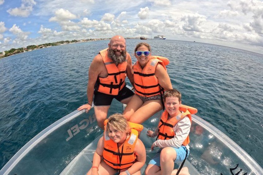A group of people on a boat with life jackets, water, and a distant shoreline. 5