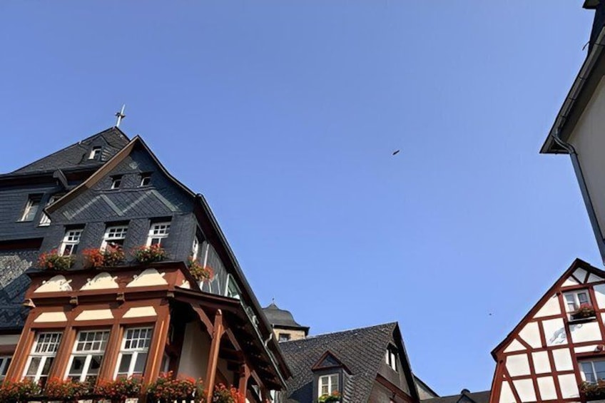 A building with a steep roof and a cross on top, under a clear blue sky. 3