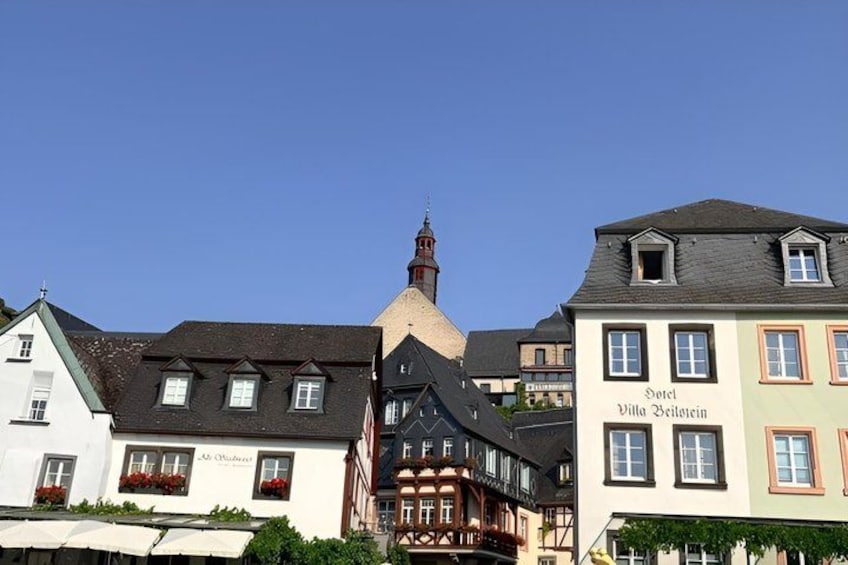 A traditional European town with historic buildings, including a hotel named 'Hotel Villa Weisswein.' 4