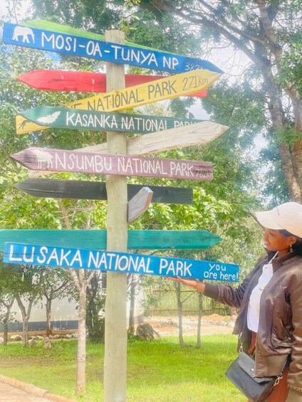 A wooden signpost with multiple directional signs pointing to various national parks. 3