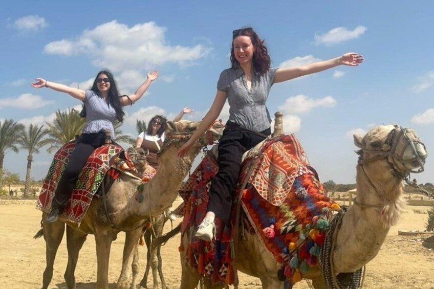 Three camels with riders in a desert landscape. 1
