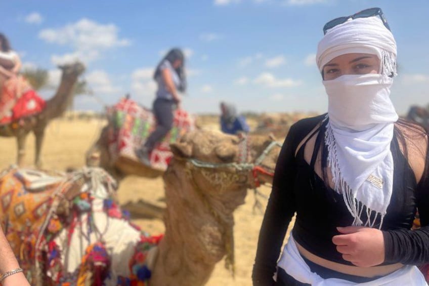 A person with a bandaged head, a camel, and a desert landscape. 3