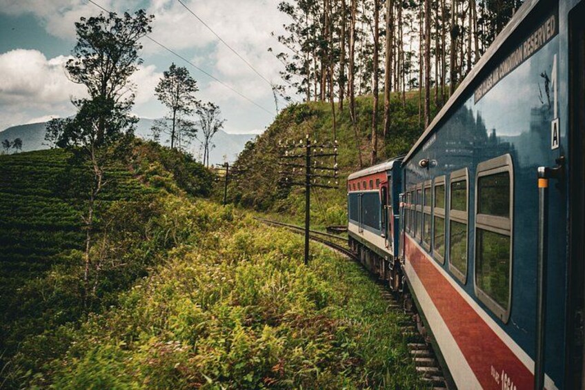 A train traveling through a lush, green landscape with hills and trees. 3
