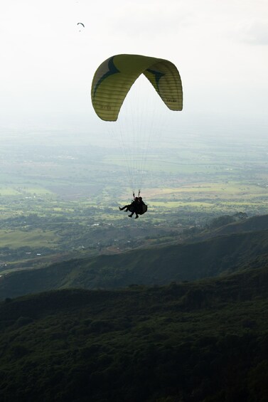 A person parachuting over a hilly landscape. 2