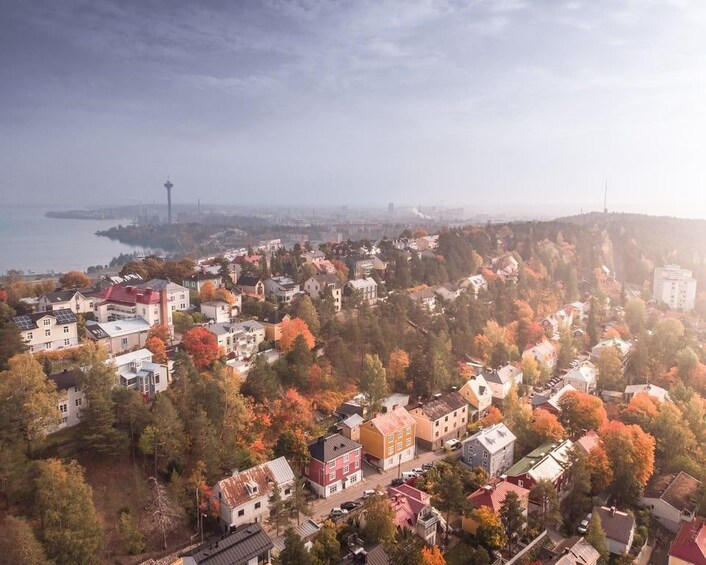 A coastal town with autumn foliage, a prominent tower, and a hilly backdrop. 3