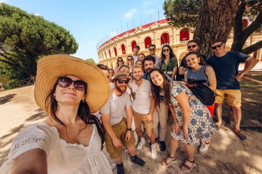 A group of people posing in front of a historical building with arches and columns. 4