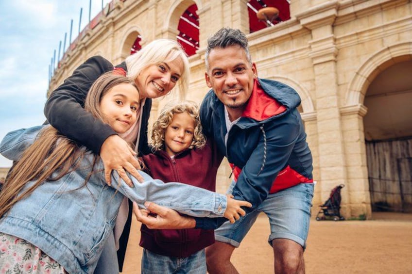 A family of four in front of a historic building with arches. 1
