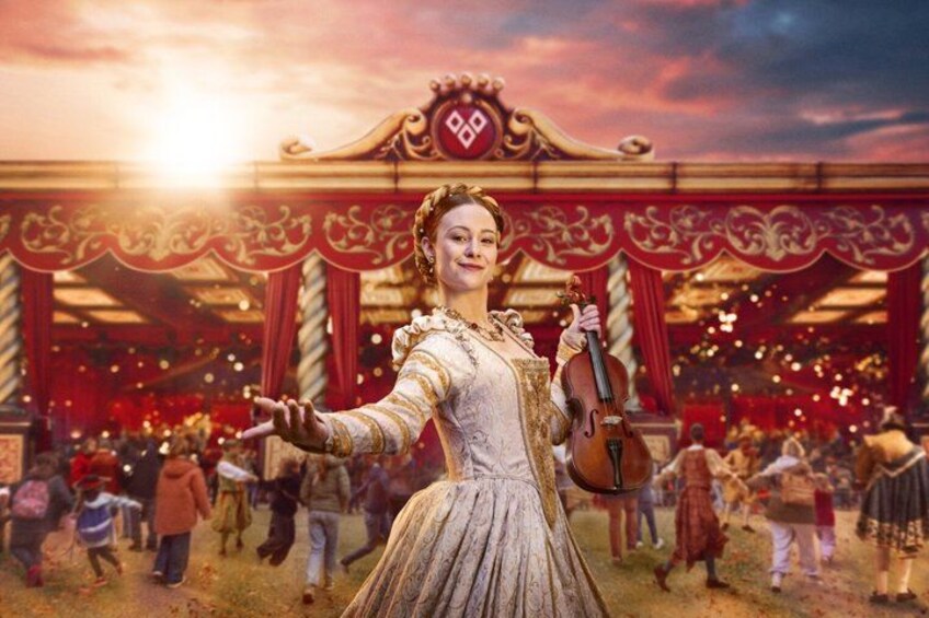A person in a dress holding a violin in front of a circus tent with red curtains and a sign with the number 99. 5