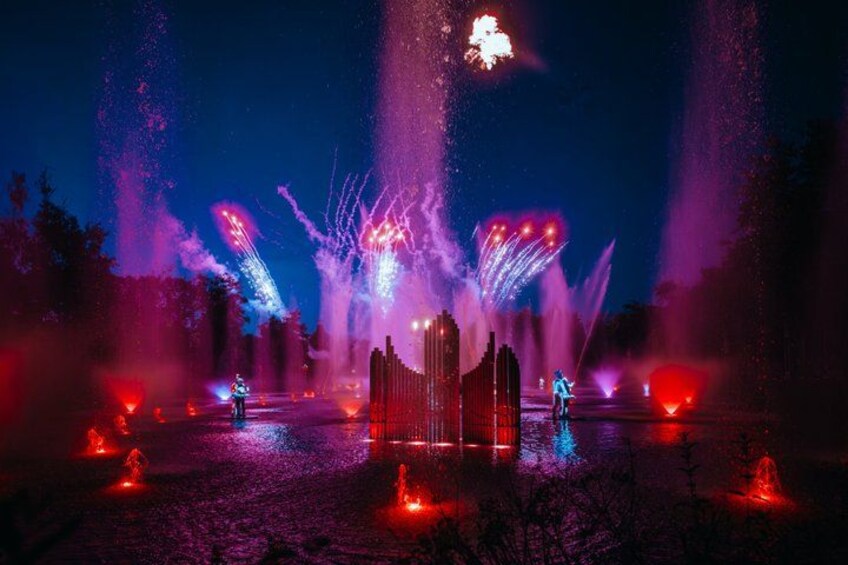 A nighttime fountain display with water jets and colorful lights. 3