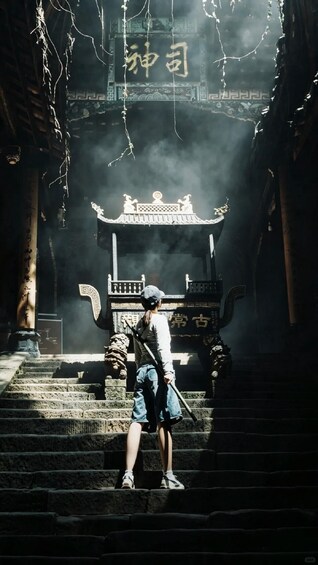 A person standing on stone steps in front of a traditional Chinese gate with intricate designs and Chinese characters. 1
