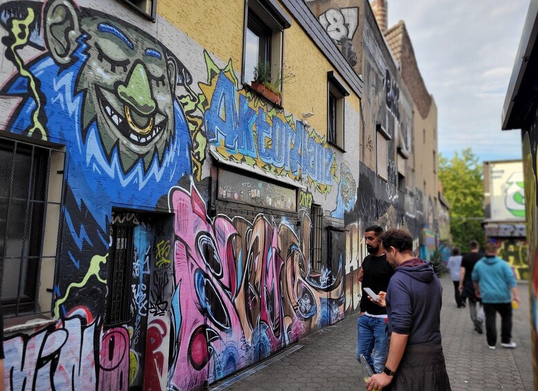 A colorful graffiti-covered wall with a face and abstract designs. 5