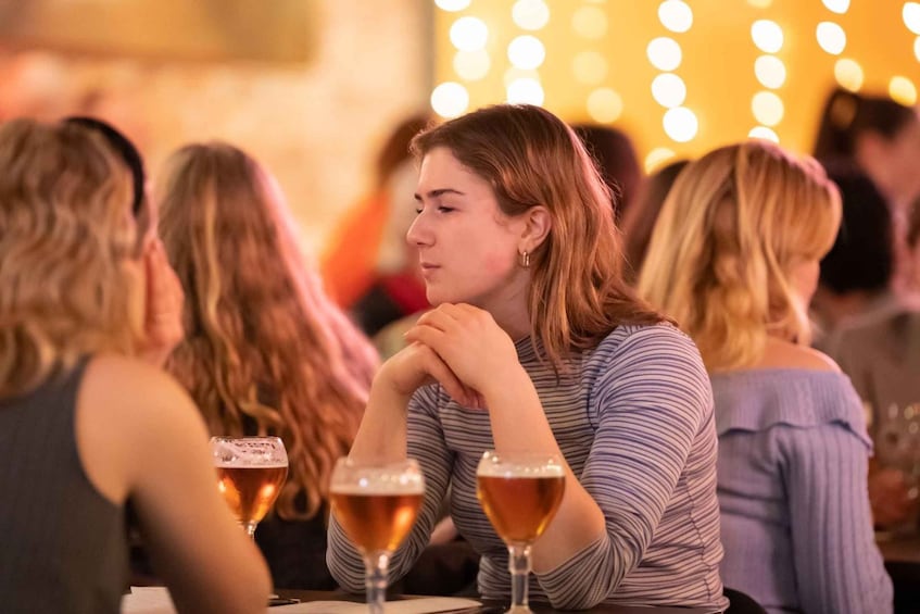 Une personne est assise à une table devant deux verres de bière. 3