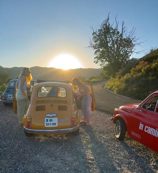 A vintage van parked on a gravel road with a sunset in the background. 2