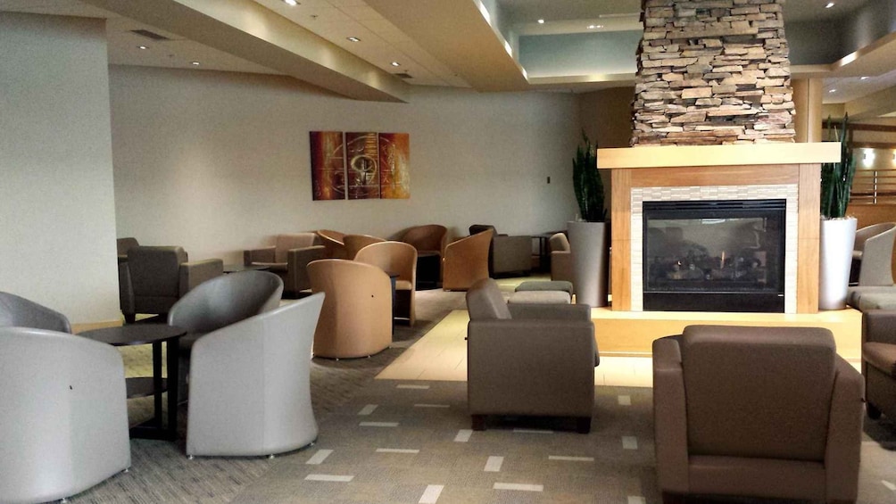 A modern lounge area with sofas, a fireplace, and a decorative wall piece. 4