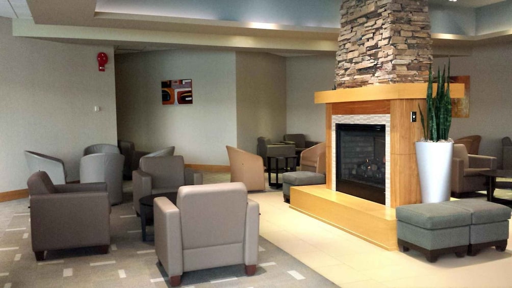 A lobby with sofas, a fireplace, and a stone accent wall. 3