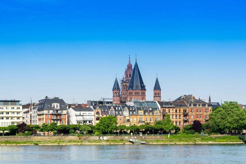 A river with buildings and a prominent church with a tall spire. 1