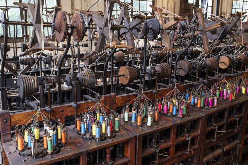 A textile factory with multiple spinning machines and spools of colorful thread. 2
