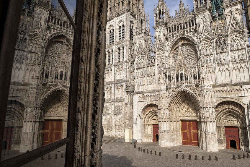 A Gothic cathedral with intricate stone carvings and multiple red doors. 1