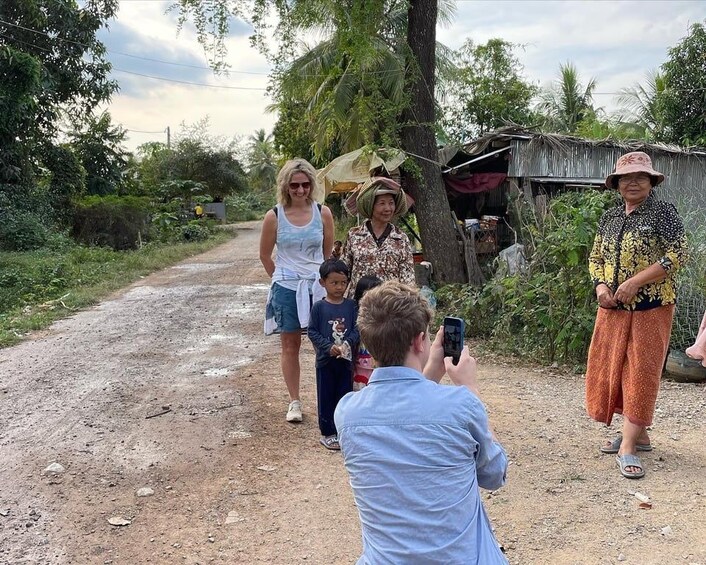 Un groupe de personnes marchant sur un chemin de terre, entouré de verdure. 1
