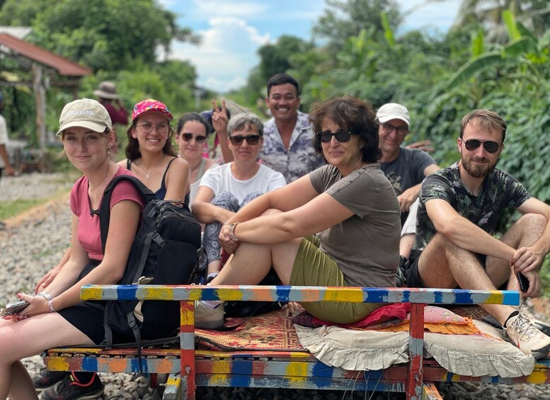 Un groupe de personnes est assis sur un banc coloré, dans un cadre naturel. 2