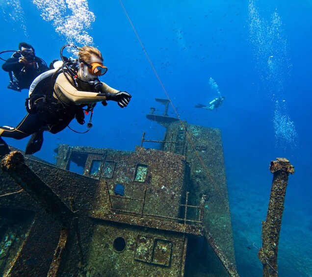 Divers exploring an underwater shipwreck. 1
