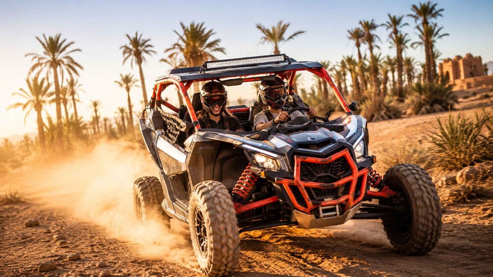 A red and black off-road vehicle driving on a dusty path with palm trees in the background. 1