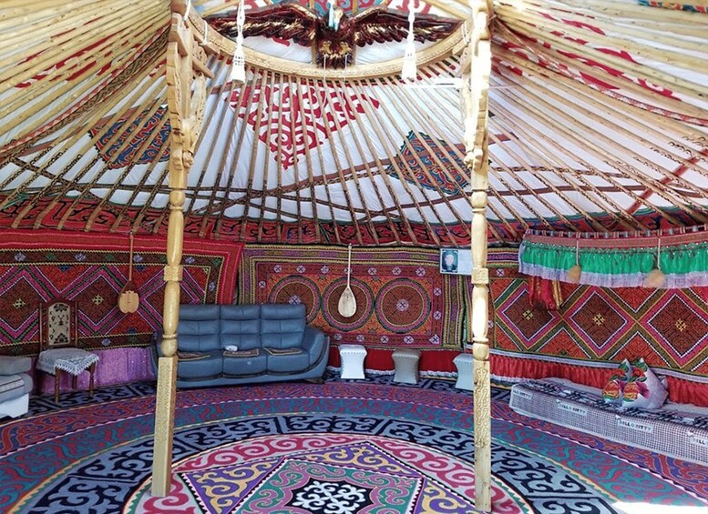 Una yurta tradicional con paredes de colores y un diseño estampado, y un sofá azul. 1