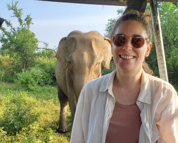 Una persona in un ambiente naturale con un elefante sullo sfondo. 3
