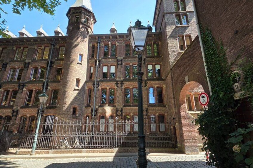 A historic building with a tower, arched windows, and a wrought iron fence. 5